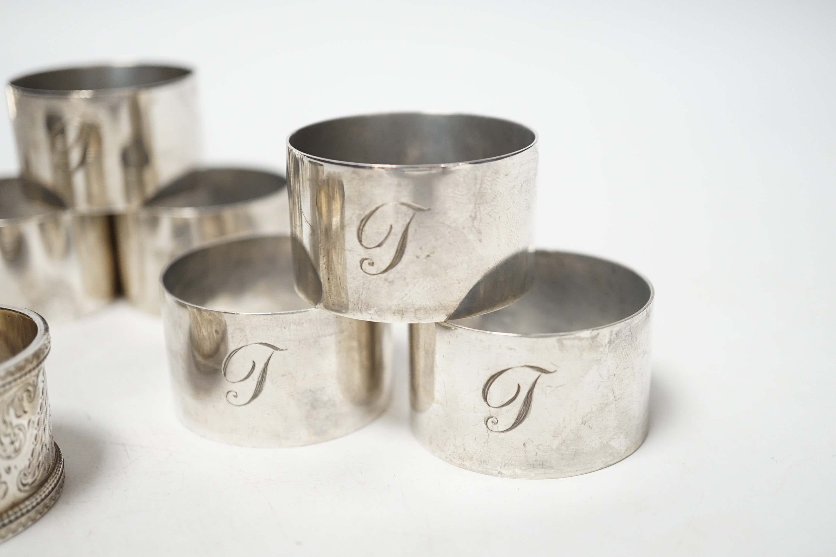 A set of six silver napkin rings, Robert Pringle & Sons, London, 1953, two other silver napkin rings and a silver five bar toast rack, 9.8oz.